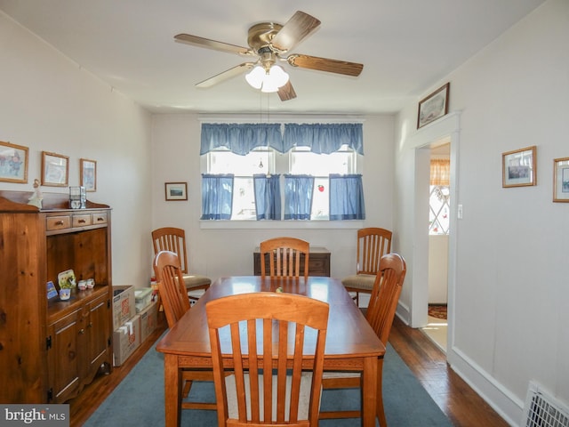 dining space featuring baseboards, wood finished floors, visible vents, and ceiling fan