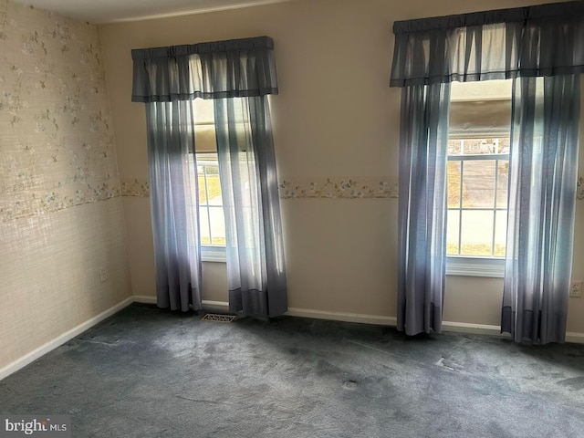 carpeted spare room with visible vents and baseboards