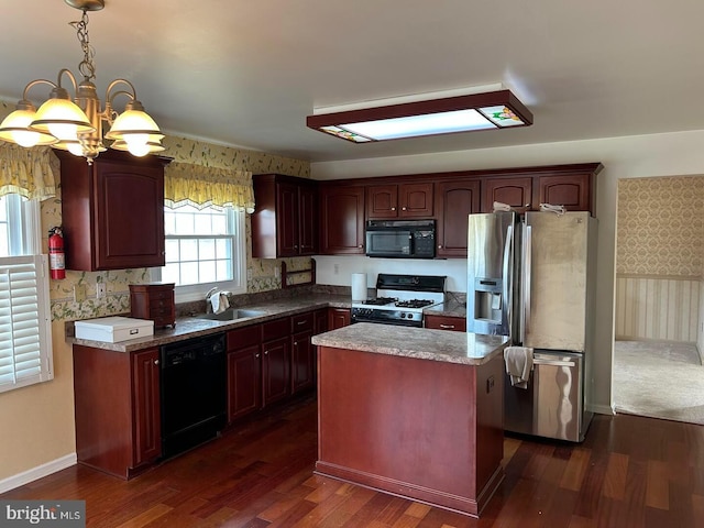 kitchen with a center island, dark wood-type flooring, decorative light fixtures, black appliances, and a sink