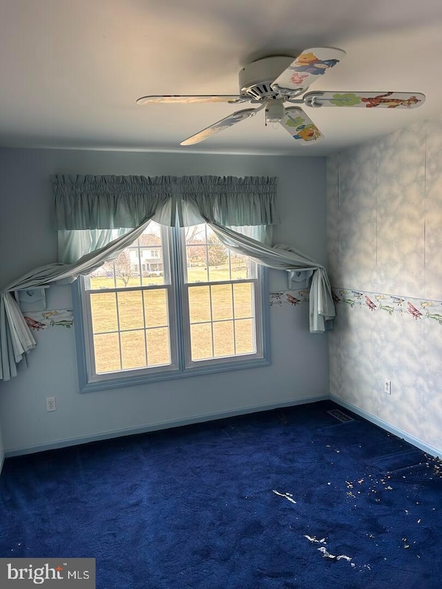 empty room featuring carpet flooring, baseboards, and ceiling fan