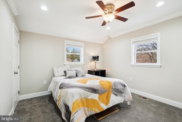 carpeted bedroom with lofted ceiling, multiple windows, baseboards, and visible vents