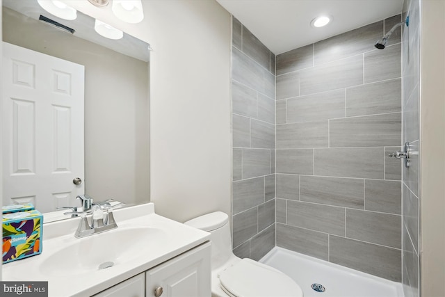 bathroom featuring vanity, a shower stall, and toilet