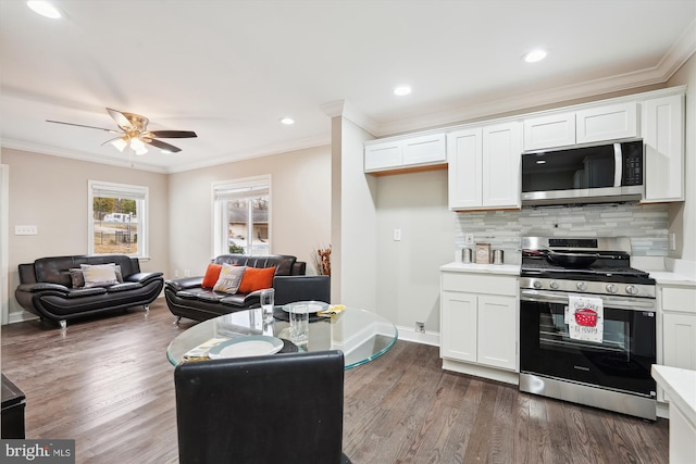 kitchen with decorative backsplash, light countertops, wood finished floors, and appliances with stainless steel finishes