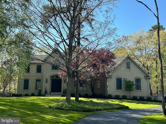 view of front of house with stucco siding and a front yard