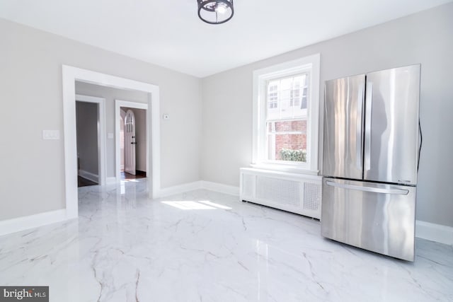 interior space with baseboards, radiator, and marble finish floor