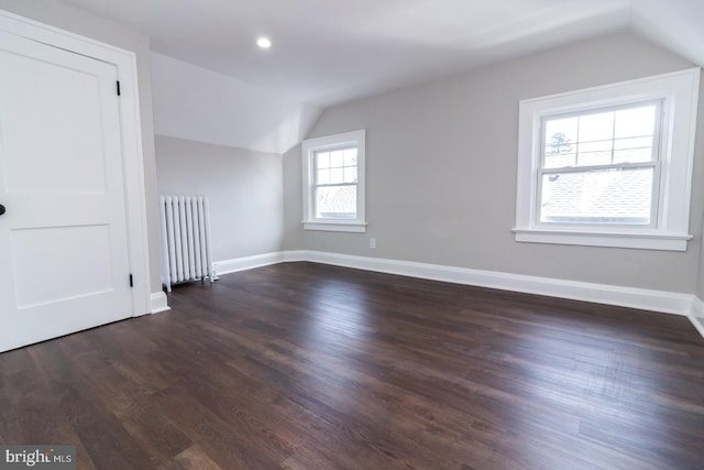 additional living space with baseboards, dark wood finished floors, radiator heating unit, lofted ceiling, and recessed lighting