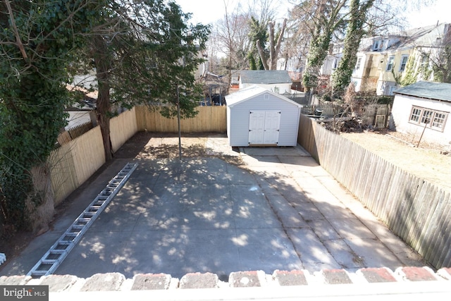 view of patio featuring an outbuilding, a fenced backyard, and a shed