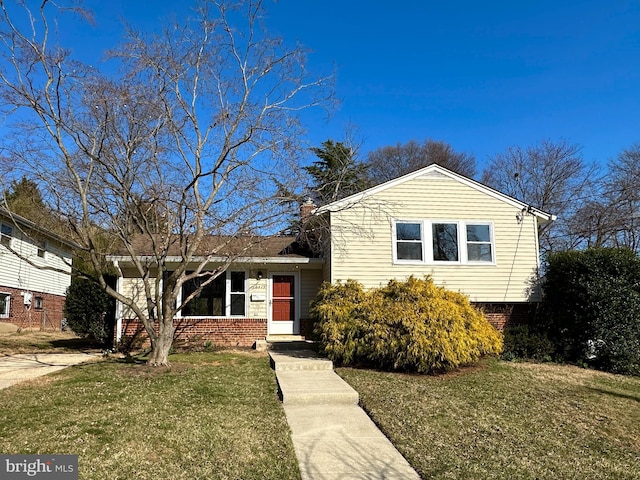 split level home featuring brick siding and a front lawn