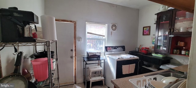 kitchen featuring washer / dryer and a sink