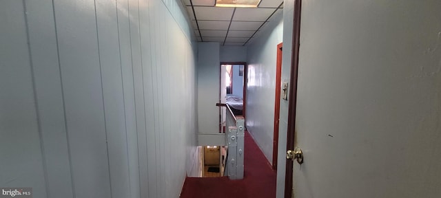 corridor with a paneled ceiling