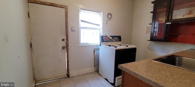clothes washing area with a sink and light tile patterned floors