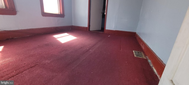 unfurnished room featuring carpet flooring, baseboards, and visible vents