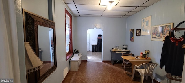 hall featuring a paneled ceiling