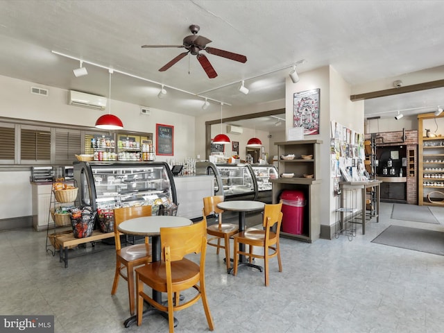 dining space featuring ceiling fan, track lighting, visible vents, and a wall mounted AC