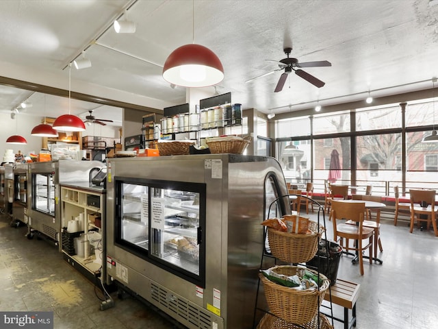 kitchen featuring rail lighting, decorative light fixtures, a textured ceiling, and a ceiling fan