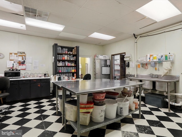 kitchen with stainless steel microwave, light floors, dark cabinets, and light countertops