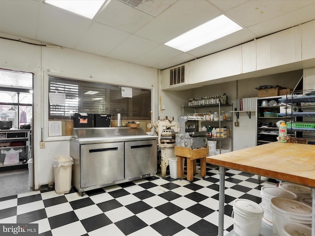 kitchen with light floors, visible vents, a drop ceiling, light countertops, and white cabinetry