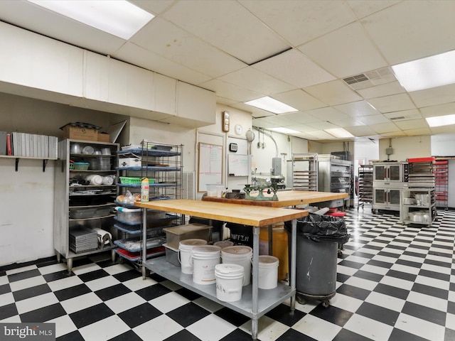 interior space featuring tile patterned floors, visible vents, and a drop ceiling