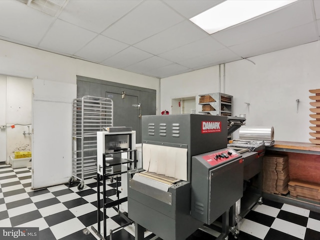 misc room featuring tile patterned floors and a drop ceiling