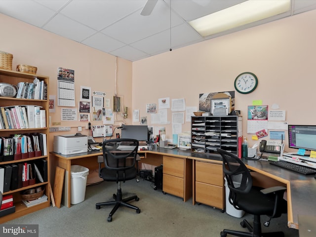 office area with a ceiling fan and a drop ceiling