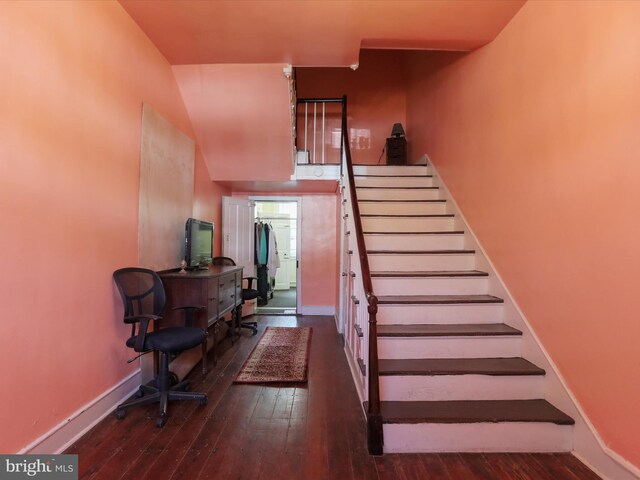 staircase featuring baseboards and hardwood / wood-style flooring