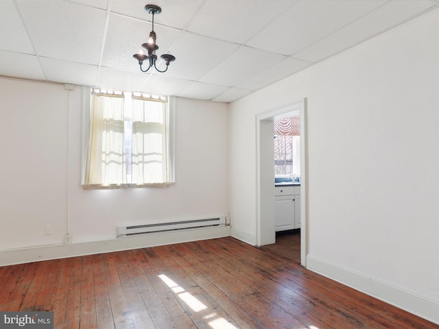 spare room featuring hardwood / wood-style floors, a drop ceiling, baseboards, and baseboard heating