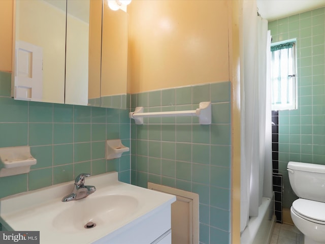 full bathroom with vanity, shower / bath combination with curtain, tile walls, toilet, and tile patterned floors