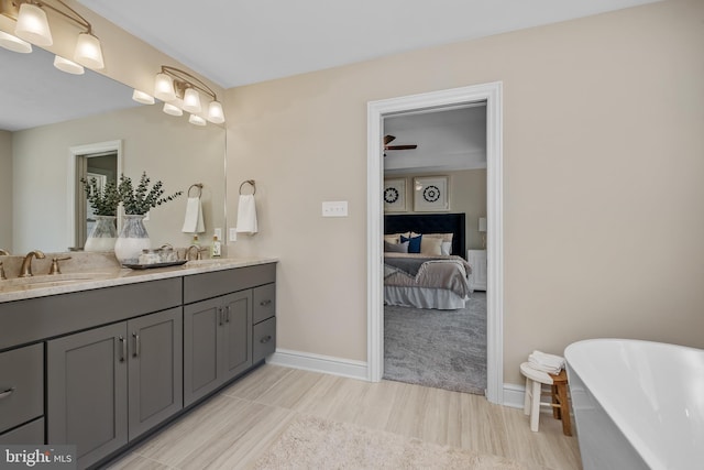 bathroom featuring a sink, a freestanding bath, ensuite bath, and double vanity