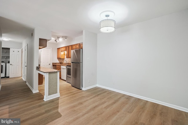 8358 Dunham Ct Unit 626, Springfield, VA 22152 - kitchen featuring freestanding refrigerator, light wood-type flooring, washing machine and clothes dryer, baseboards, and tasteful backsplash