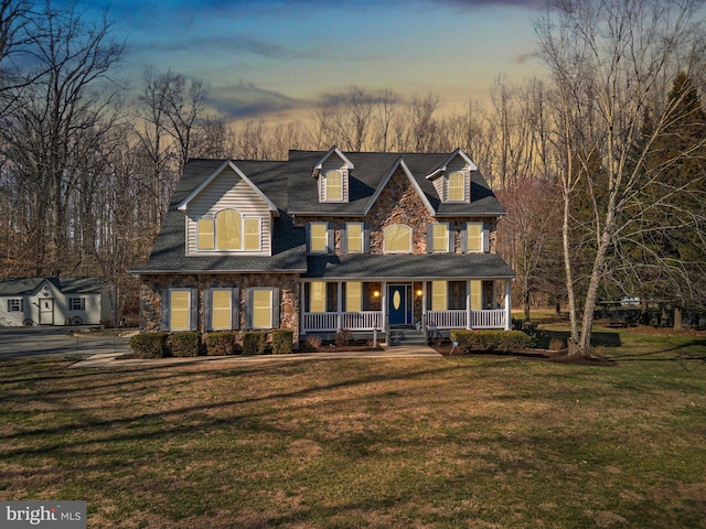 view of front of house with a porch, stone siding, and a front yard