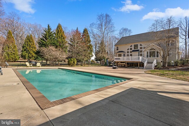 view of pool with a patio area, a fenced in pool, a wooden deck, and fence