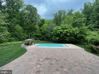 pool with a gazebo, a yard, and fence