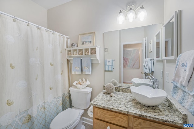 bathroom with curtained shower, toilet, and vanity