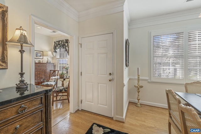 foyer with light wood-type flooring, baseboards, and ornamental molding