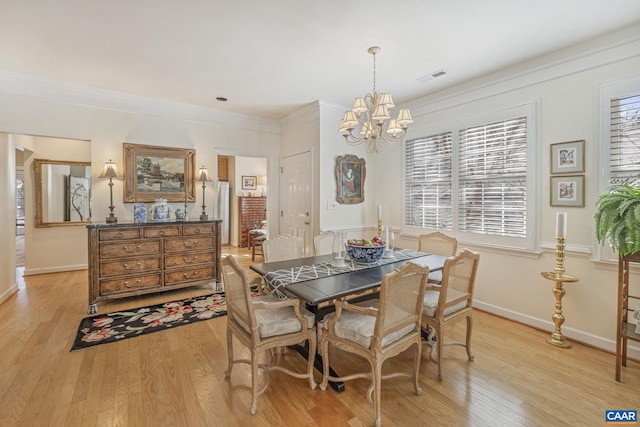 dining area with visible vents, light wood-style floors, an inviting chandelier, and ornamental molding