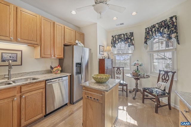 kitchen featuring visible vents, light wood-style flooring, appliances with stainless steel finishes, and a sink