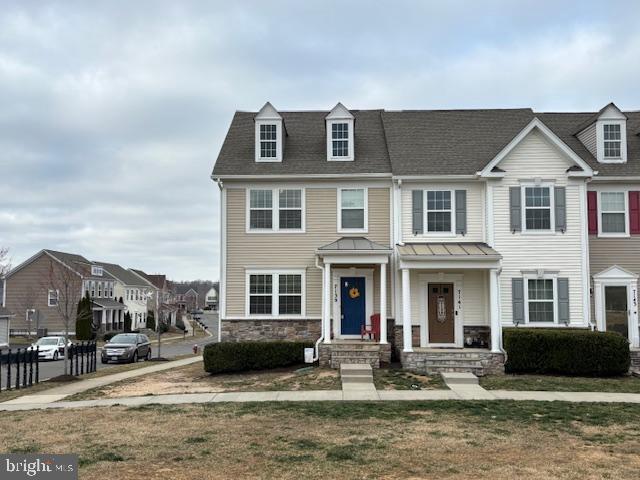 townhome / multi-family property with stone siding and a residential view