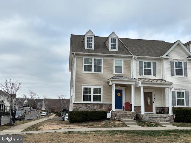 townhome / multi-family property with stone siding and a residential view