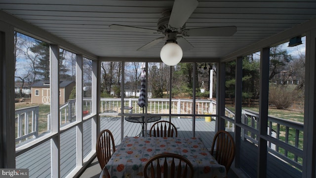sunroom featuring ceiling fan and outdoor dining space