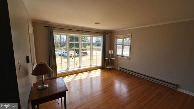 living room with crown molding, visible vents, wood finished floors, and baseboard heating
