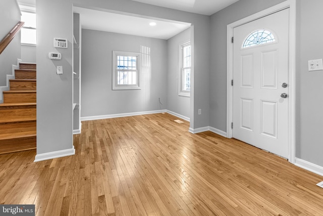 entrance foyer featuring light wood finished floors, stairway, and baseboards