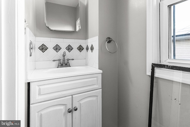 bathroom featuring vanity and tasteful backsplash