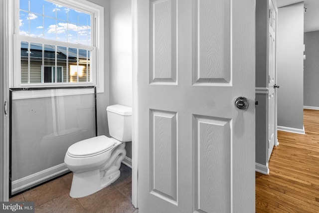 bathroom with baseboards, toilet, and wood finished floors