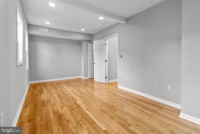 unfurnished bedroom with visible vents, beamed ceiling, recessed lighting, light wood-style floors, and baseboards