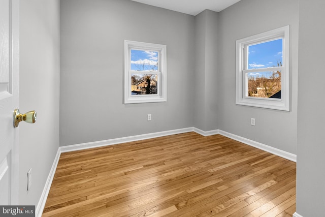 unfurnished room with plenty of natural light, light wood-style floors, and baseboards