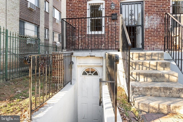 entrance to property featuring brick siding and fence