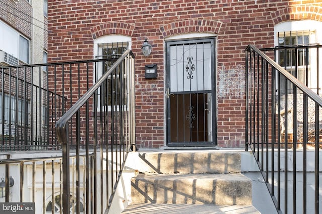 doorway to property with brick siding