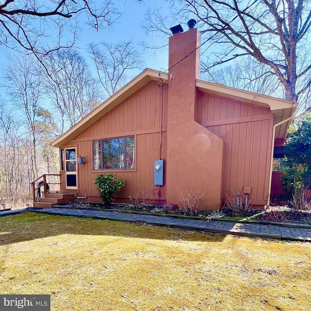 exterior space featuring a chimney and a front yard