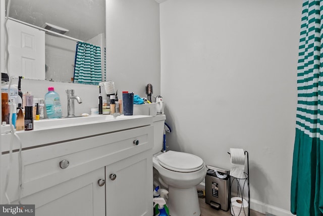 bathroom with vanity, toilet, a shower with curtain, and baseboards