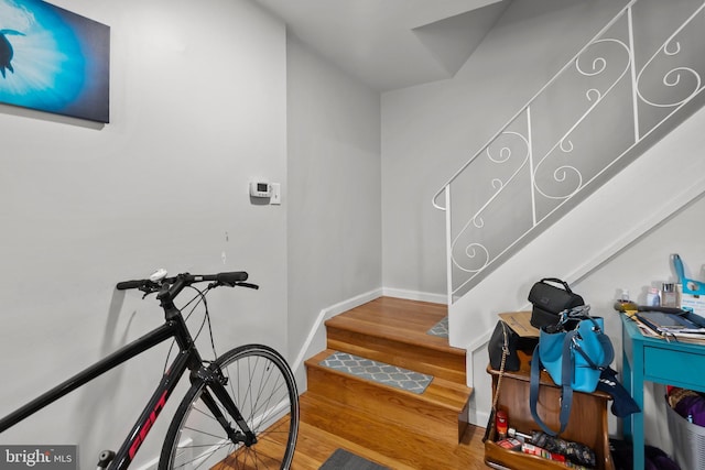 staircase featuring baseboards and wood finished floors